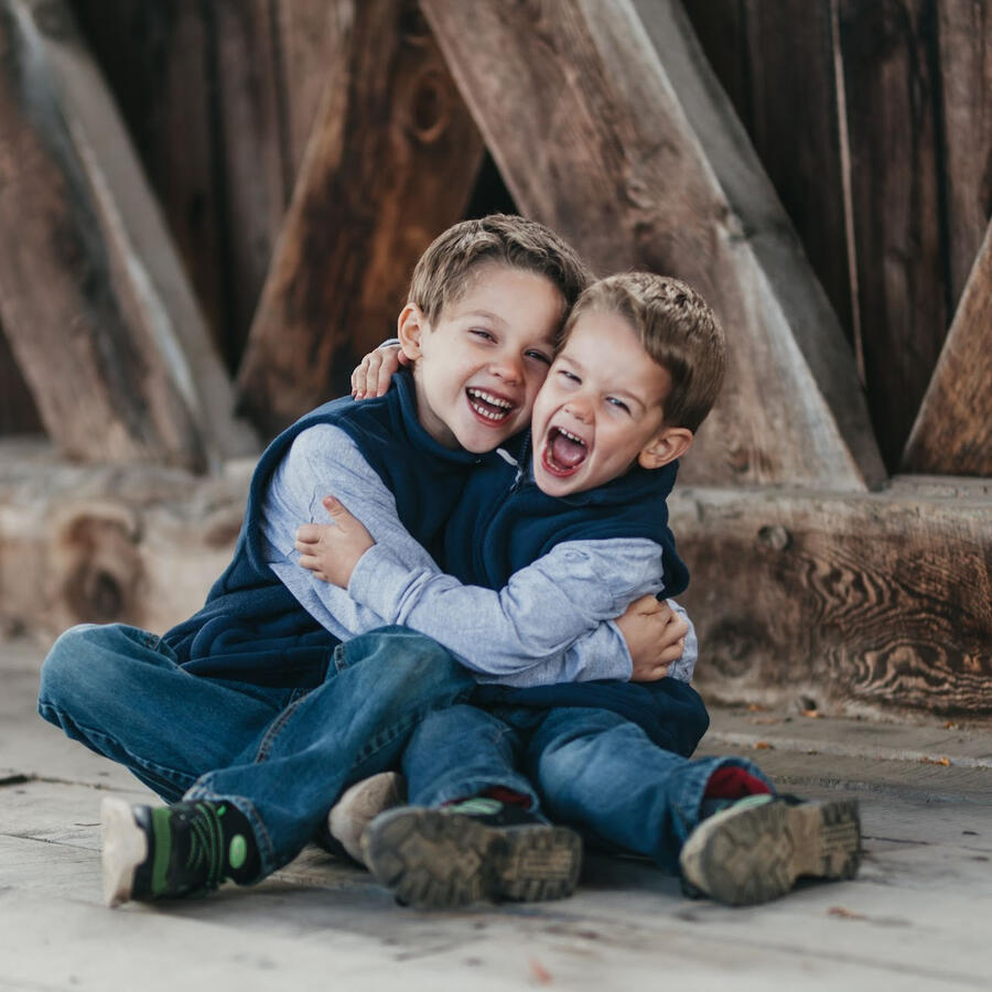 An Unspoken Art photo of two children laughing and hugging on the covered bridge in Schoharie, NY